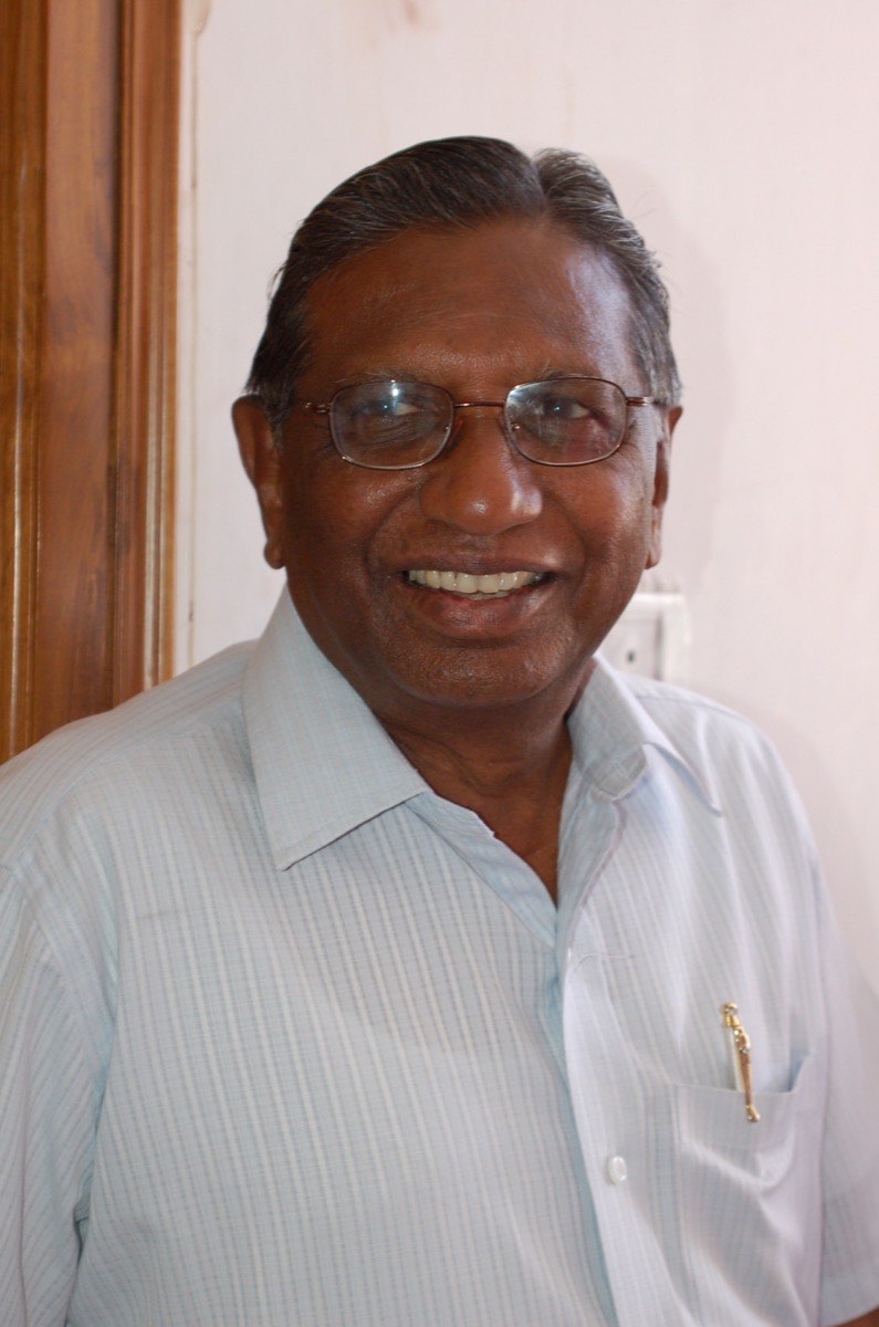 Portrait of Professor Kothapalli Jayashankar smiling, pen in his shirt pocket